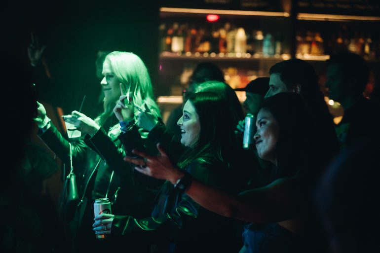 People in the crowd smiling on the dancefloor